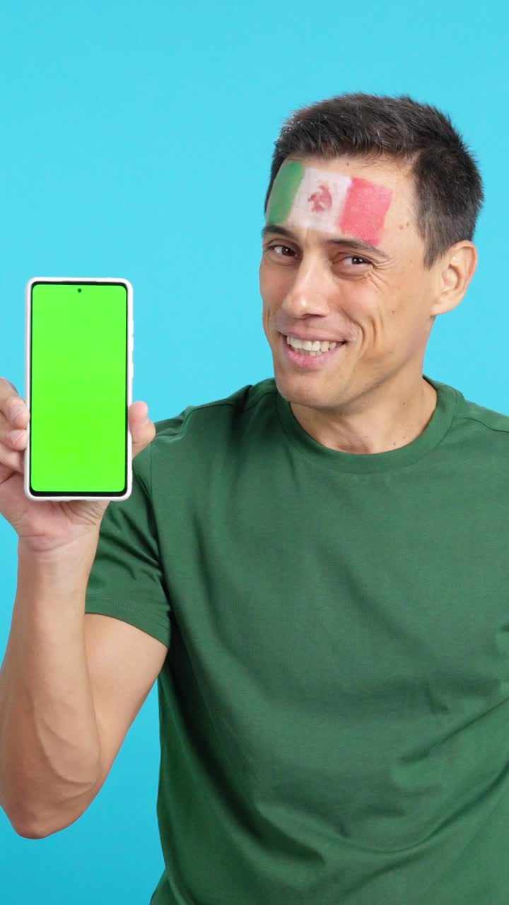 Mexican supporter looking at his mobile smiling and showing it