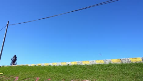side view of two men with bicycles relaxed on sunny day with clear blue sky