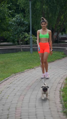 woman walking her pug in a park