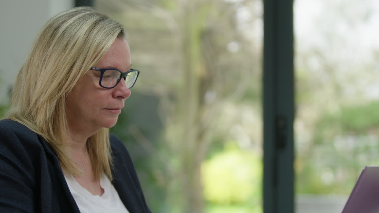 primer plano de una mujer trabajando en una oficina en casa, la cámara se mueve de izquierda a derecha