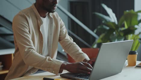 focused african american businessman typing on laptop at desk