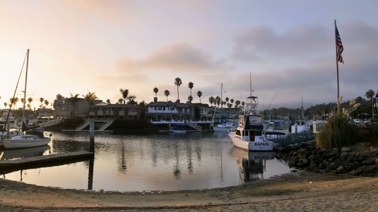 집과 보트가 늘어선 채널 위로 불고 있는 황혼의 저속 구름