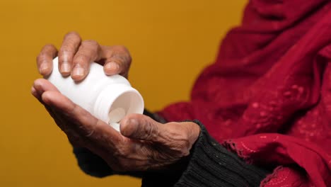 mujeres mayores tomando medicamentos de un recipiente de píldoras,
