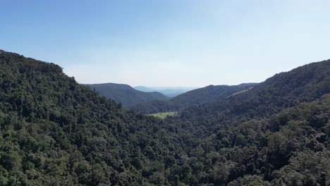 Aerial-shot-of-valley-featuring-clear-skies,-slow-dolly-backwards-'aka'-slow-push-back