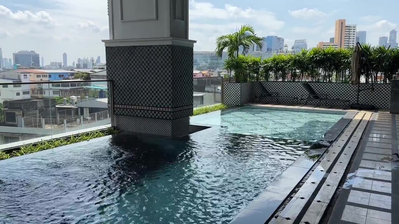 Piscina de hotel de lujo de 5 estrellas en Bangkok, Tailandia, con ángulo largo 4K y palmeras.