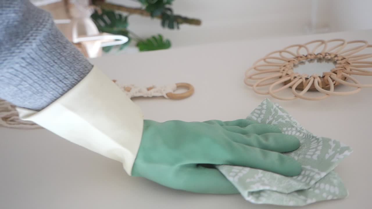 Cleaning a table with a rag and glove