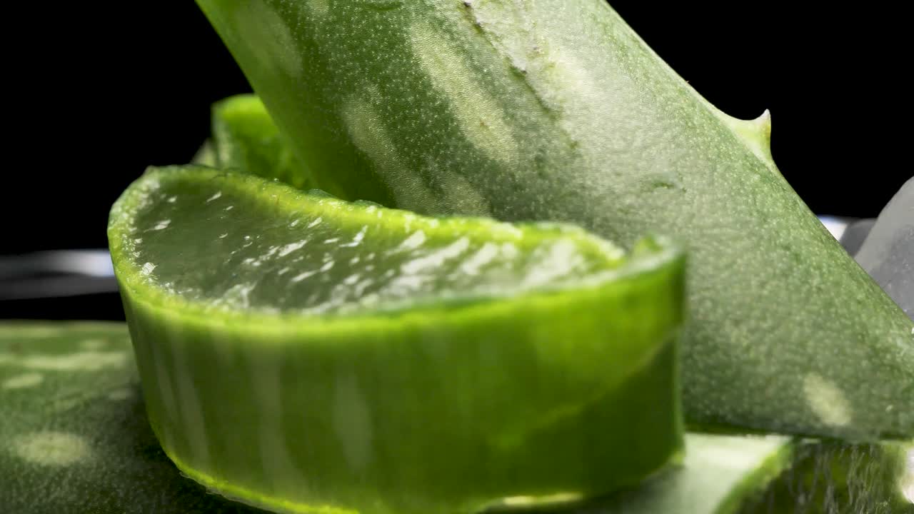 Fresh Aloe Vera Sliced on the black background, green herb concept for cosmetic and skincare product presentation, round smooth motion