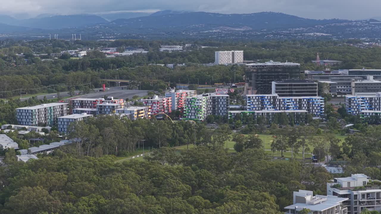 Luftfoto av Smith Collective boligområde i Southport, Queensland – Fargerike geometriske leilighetsbygg omgitt av frodige grønne trær og parkområder