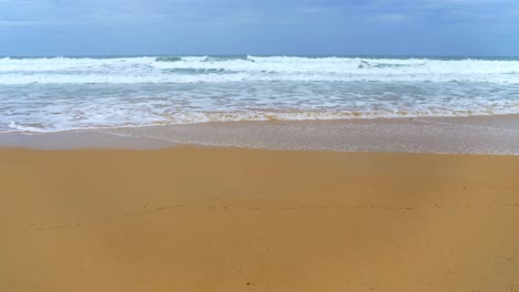 Landschaftsblick-Auf-Wellen,-Die-Sich-In-Einer-Stürmischen-Regenzeit-Am-Strandsand-Und-Am-Himmel-Brechen