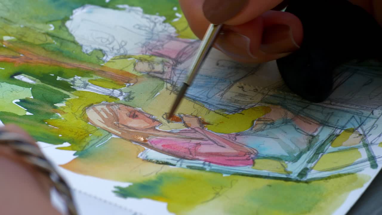 An artist painting with Water colours outdoors, closer shot 2