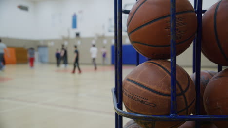 Several-basketballs-in-a-cage-during-gym-class-high-school