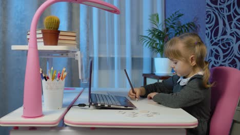 Child-schoolgirl-learning-lessons,-distance-education-at-home-sitting-at-table-using-laptop-computer