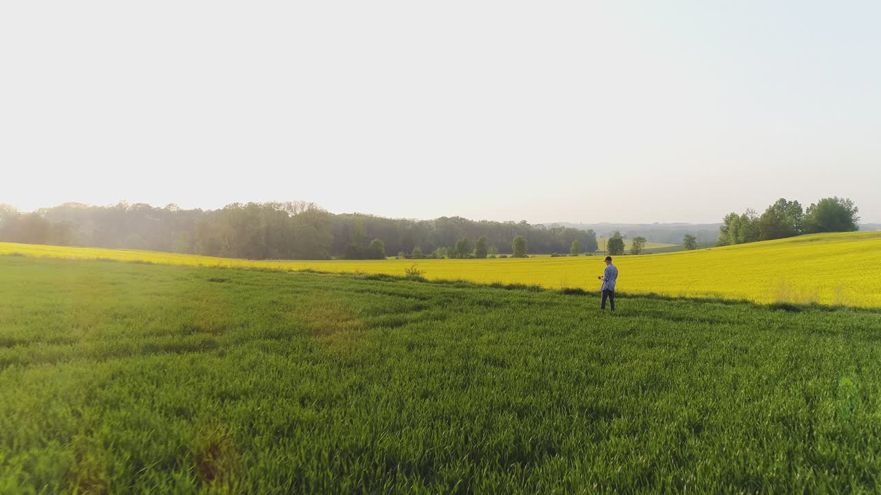 agricultor de agricultura caminando sobre un campo agrícola mientras usa una tableta digital 5