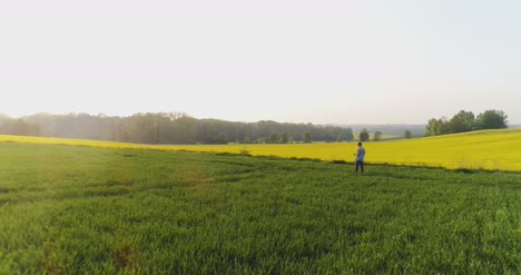 agricultor de agricultura caminando sobre un campo agrícola mientras usa una tableta digital 5