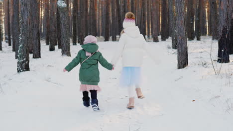 Two-Carefree-Little-Girls-Running-Through-The-Winter-Forest-Back-View