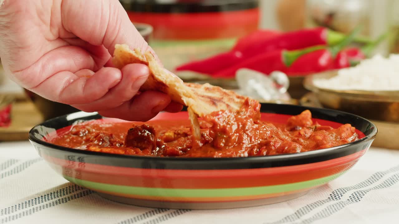 Assorted indian sri-lanka food set on wooden background. Dishes and appetisers of indeed cuisine, rice, lentils, paneer, samosa, spices, masala. Bowls and plates with indian food top view chicken. High quality 4k footage