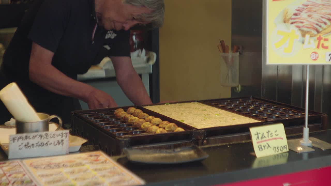 Elderly Japanese Chef Preparing Delicious Takoyaki at His Restaurant in Japan