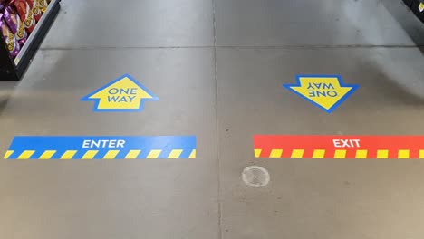 covid 19 covid coronavirus corona one way enter and exit stickers and arrows on concrete floor of store during pandemic