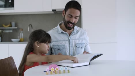 little girl and her dad reading and discussing book