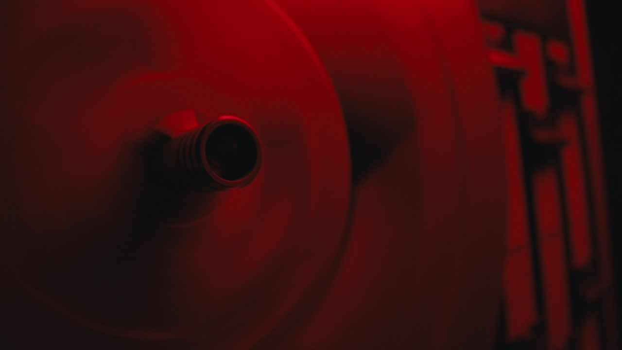 A close-up on a vintage tape recorder in a red blinking light