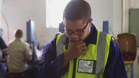 mixed race man using tablet computer in factory