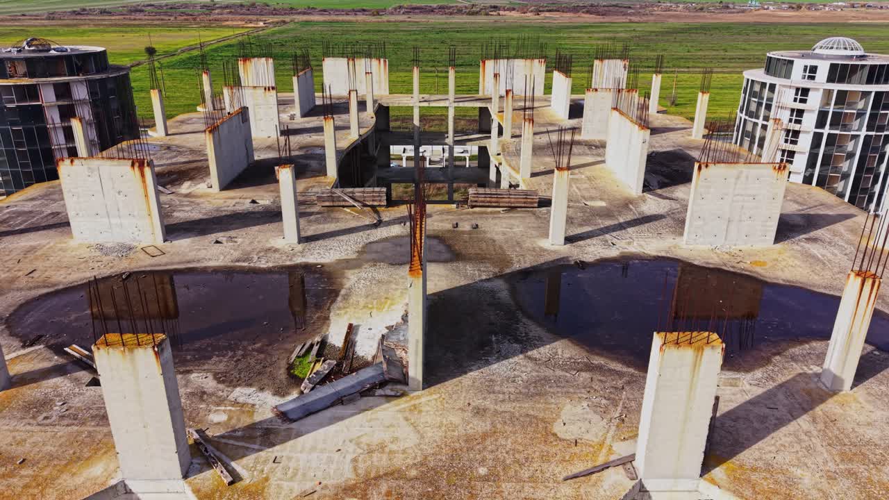 Abandoned construction site with exposed concrete and rebar at sunset
