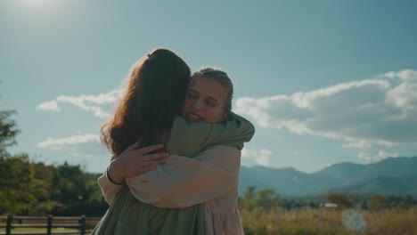 dos mujeres abrazándose al aire libre