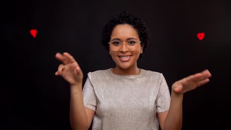 Happy-Woman-in-Glasses-Dancing-with-Glowing-Lines.leisure-and-people-concept--happy-african-american-woman-in-glasses-dancing-over-black-background-with-animated-glowing-neon-lines