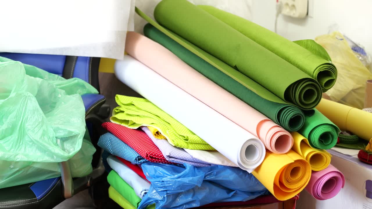 rollos de tela de colores brillantes apilados con tela plegada en la fábrica de juegos