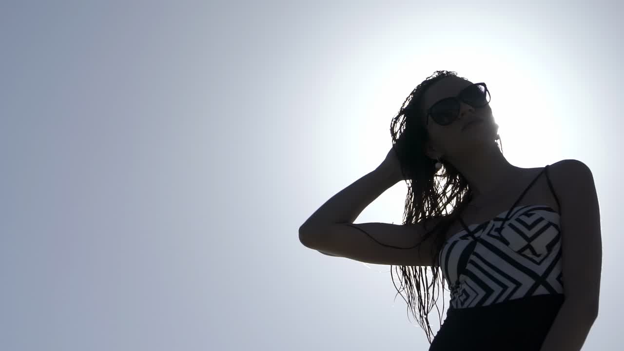 은 날 음악을 듣는 수영복을 입은 여자