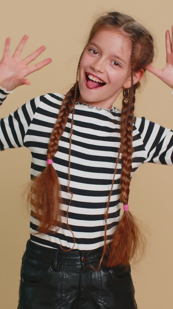 Cheerful funny bully child girl showing tongue making silly faces fooling around joking teasing