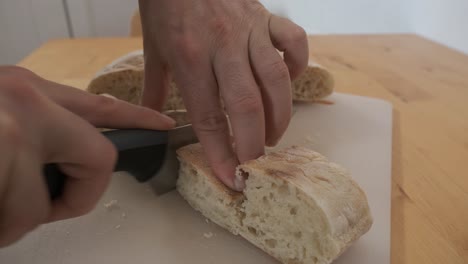 hands cut typical bread from madeira called bolo do caco