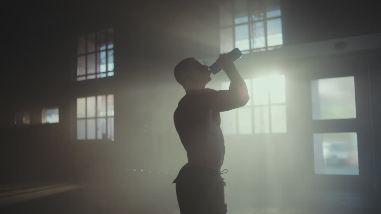 체육관 에서 운동 을 한 후 물 을 마시는 사람