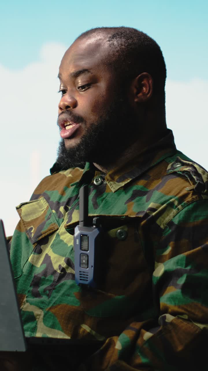 Vertical video Military personnel on offshore rig monitoring operations with laptop