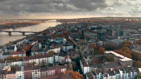 ciudad de mainz de biontech que muestra la parte neustadt con la iglesia christus y el río rin en la parte de atrás en el mejor de los casos luz naranja de otoño con un disparo aéreo de drones