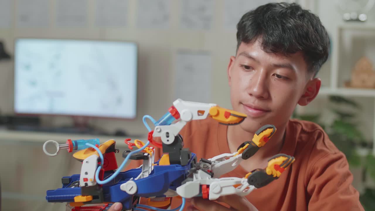 un niño asiático con una computadora portátil chequeando una mano de cyborg en casa.