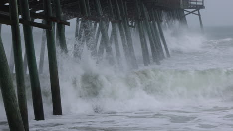olas de huracán chocando contra el muelle en cámara lenta, tiro apretado