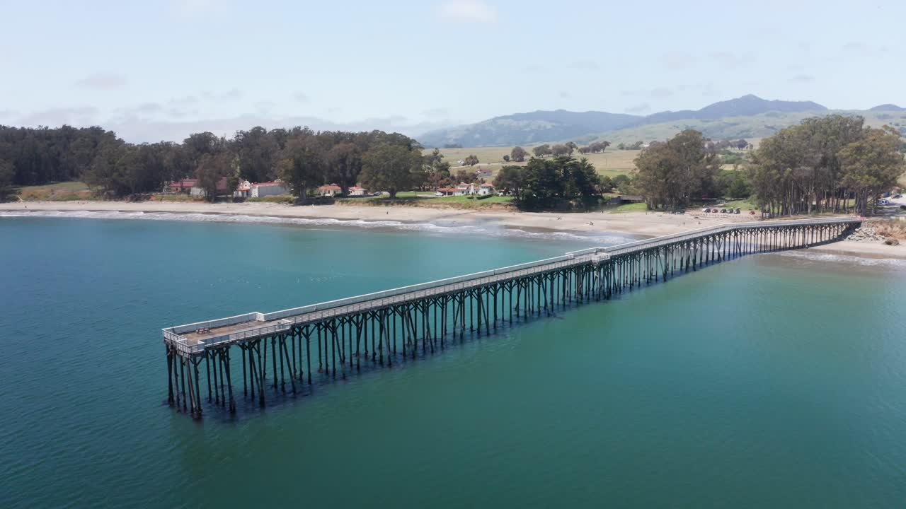 캘리포니아 중부 해안의 올드 샌 시메온 마을에 있는 윌리엄 랜돌프 허스트 메모리얼 비치 피어 (william randolph hearst memorial beach pier) 의 낮은 공중 패닝