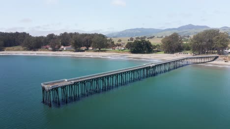 Toma-Panorámica-Aérea-Baja-Del-Muelle-De-La-Playa-Conmemorativa-De-William-Randolph-Hearst-En-El-Antiguo-Pueblo-De-San-Simeón-En-La-Costa-Central-De-California.