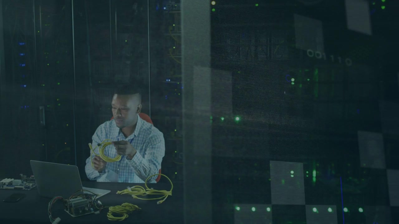 IT-Techniker handhabt gelbes Netzwerkkabel am Rack, überprüft das Einstecken und konfiguriert das Netzwerk über einen Laptop.