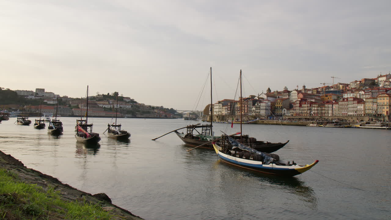 Traditional Rabelo Boats With Wine Barrels In Douro River In Porto, Portugal. Wide static shot