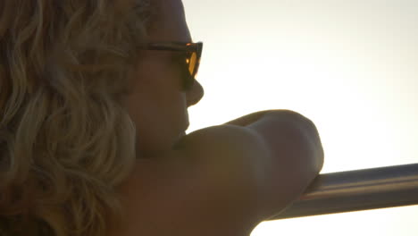 girl on railing looking out to the sunset