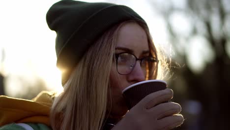 portrait of a woman drinking a hot drink, steam from hot coffee or tea, len flares