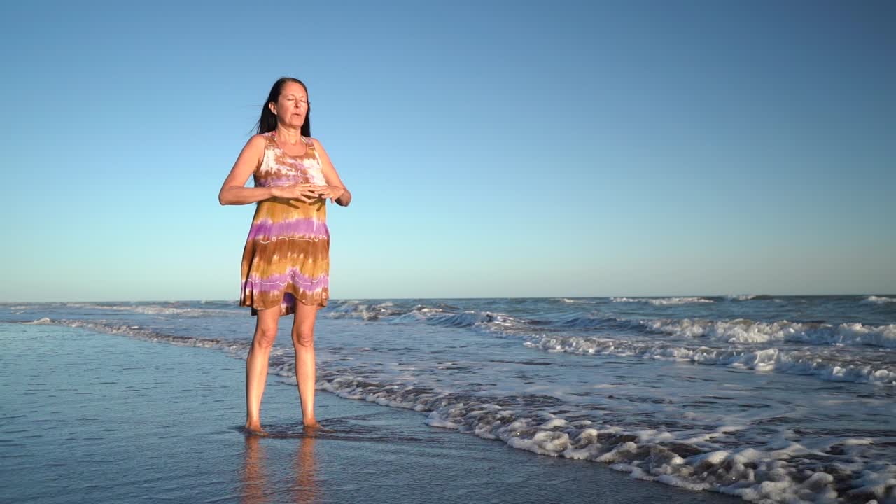 A Woman Performing A Breathing Exercise At The Seaside. Full Body Shot