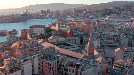 Golden-hour-aerial-view-over-buildings-of-historic-Porto-Antico-in-Genoa,-Italy