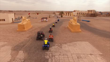 Toma-Aérea-Siguiendo-De-Cerca-A-Un-Grupo-De-Quads-En-El-Desierto-De-Ouarzazate