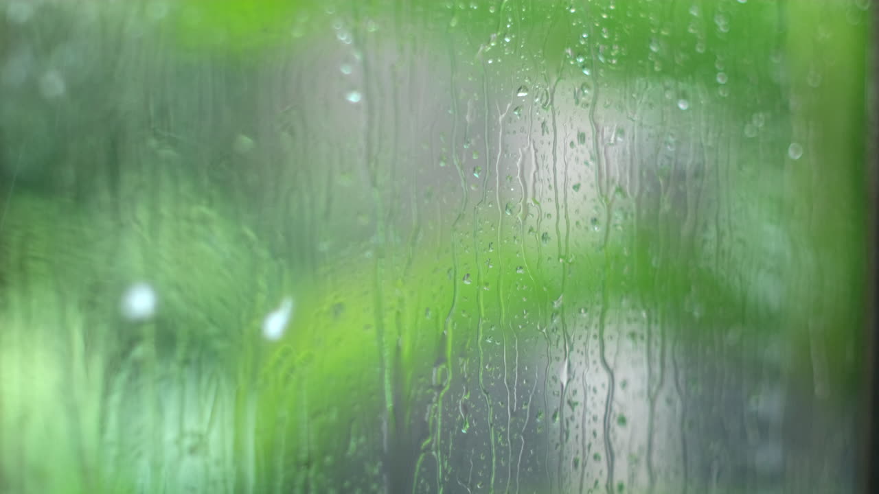 Rivulets from raindrops running down outside of window, selective focus