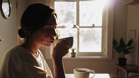 woman enjoying coffee by the window in the morning