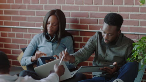 young african american business team using mobile computer technology brainstorming sharing development ideas students relaxing studying in startup company office