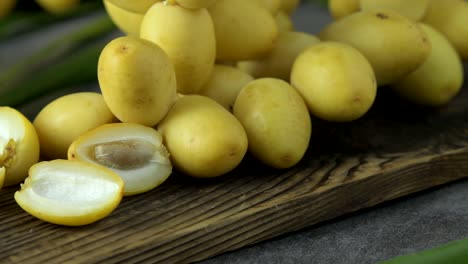 las palmeras de dátiles frescas se colocan en la mesa con aceite, concepto de alimentos saludables. palmeras de dátils. frutas crudas de palmieras de dátiles (phoenix dactylifera)